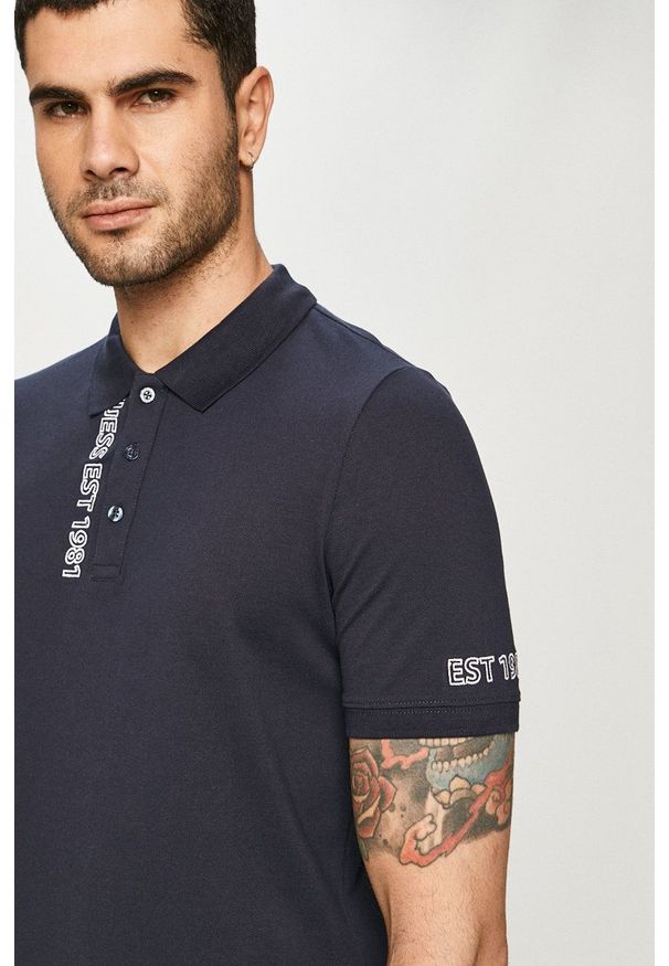 Guess - Polo. Okazja: na co dzień. Typ kołnierza: polo. Kolor: niebieski. Długość: krótkie. Wzór: nadruk. Styl: casual