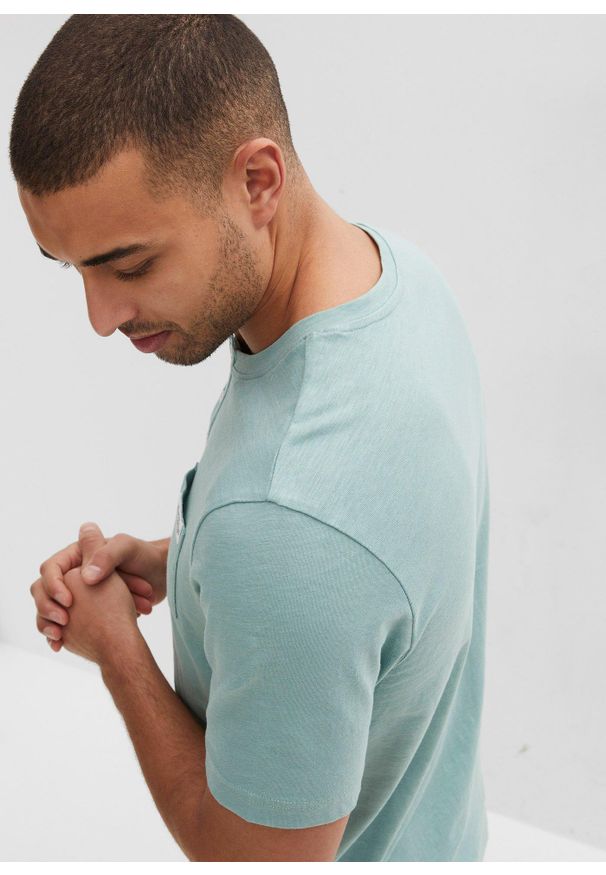 bonprix - Shirt z dekoltem henley i krótkim rękawem, w wygodnym fasonie, z czystej bawełny. Typ kołnierza: typu henley. Kolor: zielony. Materiał: bawełna. Długość rękawa: krótki rękaw. Długość: krótkie. Wzór: aplikacja