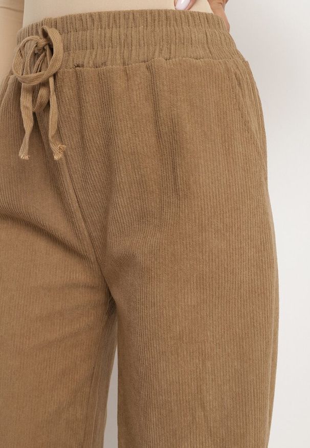 Born2be - Ciemnobeżowe Szerokie Spodnie z Wysokim Stanem Wiązane Sznurkiem Cosetta. Okazja: na co dzień. Stan: podwyższony. Kolor: beżowy. Styl: elegancki, casual