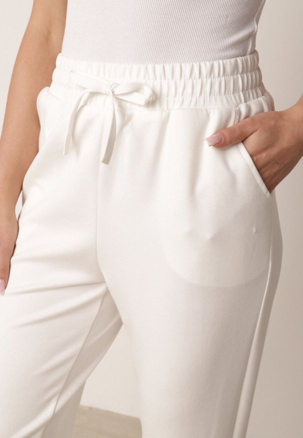 Born2be - Białe Spodnie Dresowe Joggery z Wysokim Stanem i Ściągaczami przy Kostkach Janlea. Okazja: do domu, na co dzień, na spacer. Stan: podwyższony. Kolor: biały. Materiał: dresówka. Długość: krótkie. Styl: sportowy, klasyczny, casual
