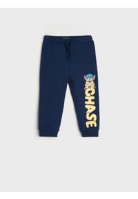 Sinsay - Spodnie dresowe Psi Patrol - granatowy. Kolor: niebieski. Materiał: dresówka. Długość: długie. Wzór: nadruk #1