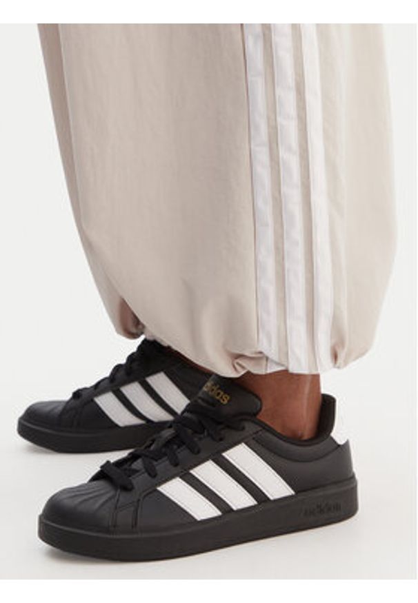 Adidas - adidas Spodnie dresowe Essentials 3-Stripes JC8168 Beżowy Loose Fit. Kolor: beżowy. Materiał: syntetyk